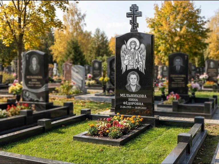 Памятник с гравировкой иконы: округлая стела-медальон с ликом — гравировка Богородицы «Семистрельная», луговые травы и полевые цветы за участком, работа «Гущин» в Омске