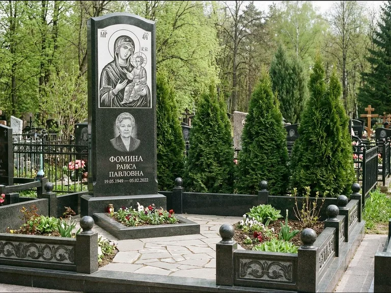 Памятник с гравировкой иконы: высокий гранёный обелиск с крестом-навершием — гравировка образа Матроны Московской, открытый участок без ограды, работа «Третьяков» в Омске
