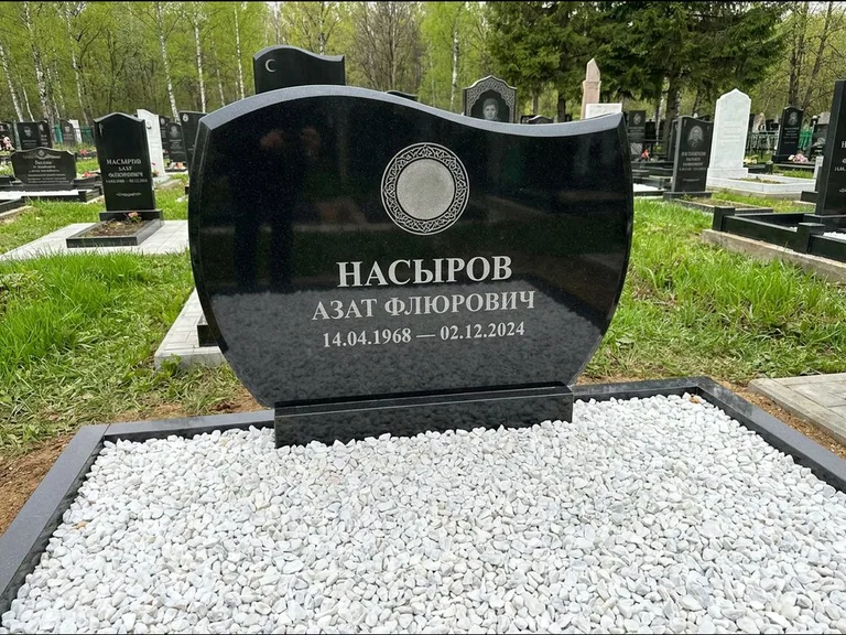 Мусульманский памятник: стела с волнообразным скошенным верхом — гравировка мечети под полумесяцем и звёздами, белая мраморная крошка с бордюром, работа «Насыров» в Омске