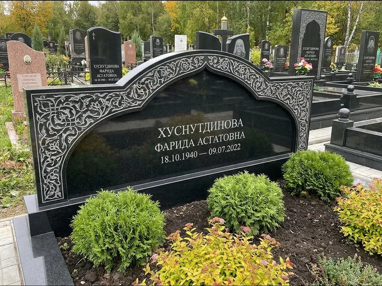 Мусульманский памятник: вытянутая горизонтальная семейная стела с аркой — белая гравировка силуэта мечети с минаретами, участок с декоративными кустами, работа «Зарипова» в Омске