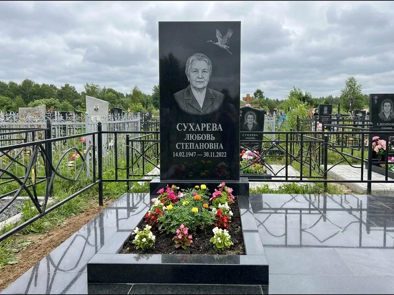 Памятник с гравировкой журавлей — гравировка одиночного летящего журавля над портретом, работа «Сухарева» в Омске