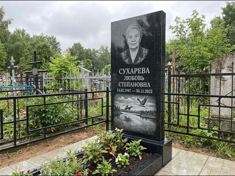 Памятник с гравировкой журавлей — гравировка пары журавлей над гладью озера в нижней части, работа «Сухарева» в Омске