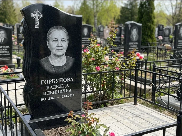 Памятник из чёрного гранита — высокий обелиск с кельтским крестом, работа «Одинцова» в Омске